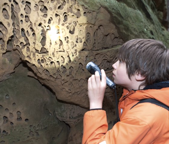 jugendlicher-felsenforscher-erkundet-die-wabenverwitterung, © Felsenland Südeifel Tourismus GmbH