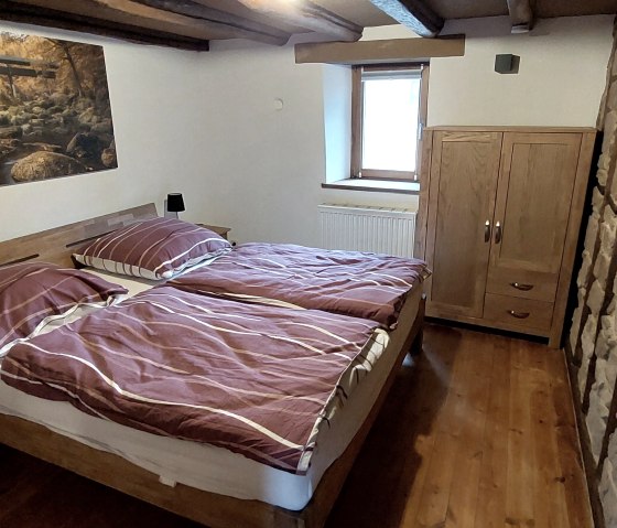 Doppelschlafzimmer mit Steinwand