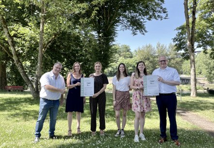 Freuen sich über die Zertifizierung der Grundschule Langsur als Naturpark-Schule (v.l.n.r.): Ralf Nehren (Ortsbürgermeister Langsur), Christina Graß (Grundschule Langsur), Daniela Torgau (Geschäftsführerin Naturpark Südeifel), Ann-Sophie Bäumer (Grundschule Langsur), Julia Dany (stellv. Schulleitung Grundschule Langsur) und Michael Holstein (Bürgermeister Verbandsgemeinde Trier-Land)., © Naturpark Südeifel/Ansgar Dondelinger