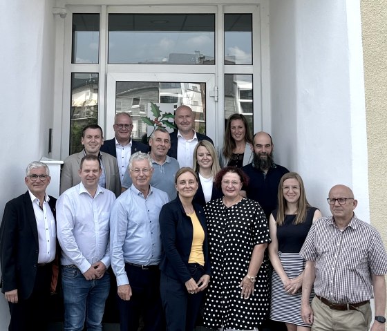 Haben den Kooperationsvertrag unterzeichnet: 1.	Reihe: Otmar Banz (Verbandsgemeindeverwaltung Bitburger Land), Ben Scheuer (Natur- & Geopark Mëllerdall), Emile Eicher (Naturpark Our), Daniela Torgau (Zweckverband Naturpark Südeifel), Francine Keiser (für die Gemeinde Parc Hosingen In Vertretung des Office Régional du Tourisme Éislek), Carole Hartmann (für die Stadt Echternach In Vertretung des Office Régional du Tourisme Région Mullerthal – Petite Suisse Luxembourgeoise), Dieter Müller (Kontaktstelle Interreg VI A Großregion für das Land Rheinland-Pfalz).  2.	Reihe: Johannes Kuhl (Bürgermeister Verbandsgemeinde Arzfeld), Alfred Wirtz („Internationa-les Sport-, Kultur- und Freizeitzentrum Ralingen-Rosport-Mompach“), Anna Carina Krebs (Bür-germeisterin Verbandsgemeinde Südeifel), Claude Daman (für die Gemeinde Weiswampach in gemeinsamer Vertretung der beiden luxemburgischen „Kooperationsgemeinden“ Weiswam-pach und Reisdorf). 3.	Reihe: Michael Holstein (Bürgermeister Verbandsgemeinde Trier-Land), Andreas Kruppert (Landrat Eifelkreis Bitburg-Prüm und Verbandsvorsteher Zweckverband Naturpark Südeifel), Janine Fischer (Bürgermeisterin Verbandsgemeinde Bitburger Land und Verbandsvorsteherin Zweckverband Feriengebiet Bitburger Land). , © Naturprk Südeifel/Ansgar Dondelinger