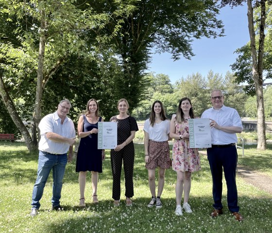 Freuen sich über die Zertifizierung der Grundschule Langsur als Naturpark-Schule (v.l.n.r.): Ralf Nehren (Ortsbürgermeister Langsur), Christina Graß (Grundschule Langsur), Daniela Torgau (Geschäftsführerin Naturpark Südeifel), Ann-Sophie Bäumer (Grundschule Langsur), Julia Dany (stellv. Schulleitung Grundschule Langsur) und Michael Holstein (Bürgermeister Verbandsgemeinde Trier-Land)., © Naturpark Südeifel/Ansgar Dondelinger