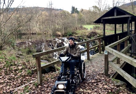 Dr. Holger Tülp testet ein Gespann aus Rollstuhl und Zuggerät auf dem zertifizierten barrierefreien Komfort-Weg rund um den Stausee Irrhausen. , © Naturpark Südeifel/Dr. Holger Tülp